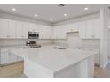 Spacious kitchen featuring an oversized island, stainless steel appliances, and bright white cabinets at 2533 Raghav Trl, Tavares, FL 32778