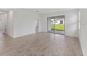 Bright living room featuring wood-look tile flooring and sliding glass doors to the backyard at 2533 Raghav Trl, Tavares, FL 32778