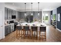 A bright kitchen with modern gray cabinetry, stainless steel appliances, and a large center island at 3114 Suraj Cir, Tavares, FL 32778