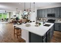 Open concept kitchen with an island, granite countertops, and gray cabinetry with stainless appliances at 3114 Suraj Cir, Tavares, FL 32778