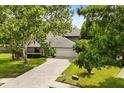 A view of the house showcasing its gray exterior, well-kept lawn, and a long driveway for easy parking at 359 Westwind Ct, Lake Mary, FL 32746