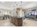 Open-concept kitchen island with bar seating, connected to the living and dining areas at 3847 Shoreside Dr, Kissimmee, FL 34746
