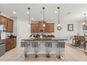 Modern kitchen with a large island, pendant lighting, granite countertops, stainless steel appliances, and an adjacent dining area at 3847 Shoreside Dr, Kissimmee, FL 34746