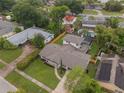 Aerial view of a home with a well-maintained lawn and proximity to other homes, a pool, and mature landscaping at 3902 Brandeis Ave, Orlando, FL 32839