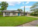 Charming single-story home featuring a well-manicured lawn, a blue front door, and an attached two-car garage at 3902 Brandeis Ave, Orlando, FL 32839