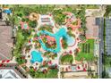 Stunning aerial view of resort-style pool area with lazy river, slides, palm trees and many lounge chairs at 3938 Calabria Ave, Davenport, FL 33897