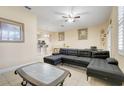 Inviting living room with tile floors, ceiling fan, and comfortable dark gray sofa with a view to the kitchen at 3938 Calabria Ave, Davenport, FL 33897
