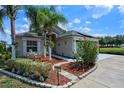 Charming home with lush landscaping, palm trees, and a paver walkway leading to the front door at 404 Obo Dr, Davenport, FL 33896