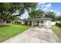 Charming single-story home featuring a long driveway, front lawn, and a covered carport at 4111 Dublin St, Orlando, FL 32812