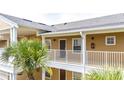 Close-up of a condo building exterior with a balcony and palm trees at 515 Rum Run # 33515, Davenport, FL 33897