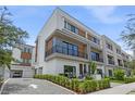 Modern townhome shows private drive, garage, and balcony with sleek architectural details and well-maintained landscaping at 52 W Harding St # A, Orlando, FL 32806