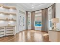 Inviting living room boasts hardwood floors, stylish built-ins, and an abundance of natural light from large windows at 6233 Rydal Ct, Windermere, FL 34786
