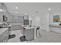 Bright kitchen features gray cabinetry, stainless steel appliances, a center island and stylish countertops at 9239 Sommerset Hills Dr, Davenport, FL 33896