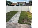 Backyard featuring a new white fence and stone pavers, ideal for relaxation and privacy at 9471 Comeau St, Gotha, FL 34734