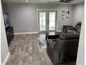 Open-concept living room featuring a ceiling fan, hardwood floors, and glass patio doors to the outdoors at 9471 Comeau St, Gotha, FL 34734