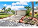 Single-story home features a large driveway, two-car garage, and mature palm trees at 963 Beach Breeze Dr, Orlando, FL 32835