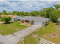 Scenic aerial view of single-story home, spacious driveway, and verdant lawn on a sunny day at 964 Clayton Dr, Deltona, FL 32725