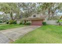 Well-maintained home with a two-car garage, green lawn, and mature trees adding character to the property at 9948 Timber Oaks Ct # 14, Orlando, FL 32817