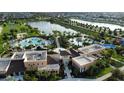 Aerial view of community pool, clubhouse, and amenities, with a lake and fountain in the background at 1544 Nassau Point Trl, Kissimmee, FL 34747