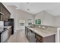 Modern kitchen featuring stainless steel appliances, granite countertops and tile flooring, offering a sleek and functional space at 2044 Hillview Cir, Deltona, FL 32738
