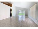 Spacious living room featuring tile floors, high ceilings, and a sliding glass door to the backyard at 2314 Cormorant St, Kissimmee, FL 34743