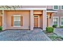 Attractive townhouse featuring brick paved driveway, tidy landscaping, and an ADT security system at 2343 Caravelle Cir, Kissimmee, FL 34746