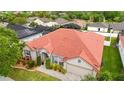 Aerial view of a well-maintained home featuring a red tile roof, screened-in pool, and lush tropical landscaping at 2359 Baronsmede Ct, Winter Garden, FL 34787