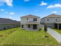 The house shows a spacious backyard with green grass, a covered patio, and a white fence at 2372 Orchid Dr, Davenport, FL 33837