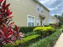 Well-maintained townhome exterior featuring manicured landscaping and colorful shrubs and plants at 2548 Galliano Cir, Winter Park, FL 32792