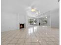 Spacious living room with tile flooring, fireplace, and a wall of mirrors reflecting natural light at 3107 Ash Park Loop, Winter Park, FL 32792