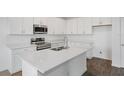 Modern kitchen with sleek white cabinetry, stainless steel appliances, an island, and granite countertops at 3144 Suraj Cir, Tavares, FL 32778