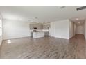 Open-concept living area with wood-look tile flooring, recessed lighting, and a view into the modern kitchen at 3144 Suraj Cir, Tavares, FL 32778