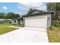 Home featuring an attached two-car garage and a long concrete driveway for easy parking at 327 Larch Rd, Ocala, FL 34480