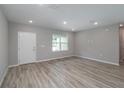 Spacious living area with wood-look flooring, a large window, and fresh neutral paint at 327 Larch Rd, Ocala, FL 34480