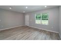 Bright living room featuring wood-look flooring, a large window, and neutral paint at 327 Larch Rd, Ocala, FL 34480