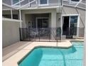 Covered outdoor patio with a dining set, enclosed by a safety fence around a pool, offering a secure dining experience at 456 Ocean Course Ave, Davenport, FL 33896