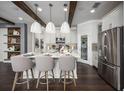 Stunning kitchen showcasing hardwood floors, island seating, stainless steel appliances, and modern lighting at 5328 Teirgarten St, St Cloud, FL 34771