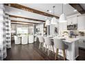 Open kitchen with dark hardwood floors, large island, modern pendant lights, and white cabinetry at 5328 Teirgarten St, St Cloud, FL 34771