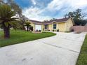 Inviting one-story home with a concrete driveway, attached garage, and meticulous landscaping at 5815 England Ave, Orlando, FL 32808