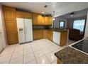 Bright kitchen with wooden cabinets, granite countertops, and white appliances at 5815 England Ave, Orlando, FL 32808