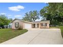 Charming single-story home featuring a well-manicured front yard and attached garage, perfect for suburban living at 5820 Indian Hill Rd, Orlando, FL 32808