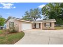 Charming single-story home featuring a well-manicured front yard and attached garage, perfect for suburban living at 5820 Indian Hill Rd, Orlando, FL 32808