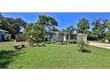Inviting front yard with lush green grass, palm trees, and a quaint seating area at 60 Palmetto Dr, Ormond Beach, FL 32176