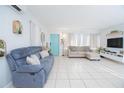 Bright living room with tile floors, comfortable seating, and a turquoise door adding a pop of color at 624 Cardinal St, Ocoee, FL 34761