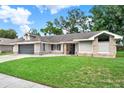 Attractive single-story home featuring a well-manicured lawn and mature trees at 679 N Endeavour Dr, Winter Springs, FL 32708