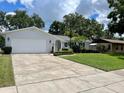 Well maintained home with a pristine lawn, an attached two-car garage and a spacious driveway at 7011 Archwood Dr, Orlando, FL 32819