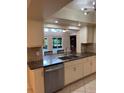 Kitchen boasts granite countertops, stainless steel appliances, and a seamless view into the dining area at 7011 Archwood Dr, Orlando, FL 32819