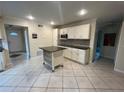 Well-lit kitchen with white cabinets, granite countertops, and a functional island at 7011 Archwood Dr, Orlando, FL 32819