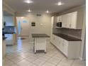 Spacious kitchen featuring tile flooring, an island, and white cabinets at 7011 Archwood Dr, Orlando, FL 32819