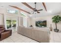 Bright living room features vaulted ceiling, wooden beams, and sliding glass doors to a covered patio at 7011 Archwood Dr, Orlando, FL 32819
